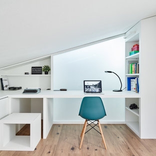 Immagine di una piccola cameretta per bambini design con pareti bianche, pavimento in laminato e pavimento beige