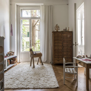 Ispirazione per una cameretta per bambini da 4 a 10 anni scandinava di medie dimensioni con pareti bianche, pavimento in legno massello medio e pavimento marrone