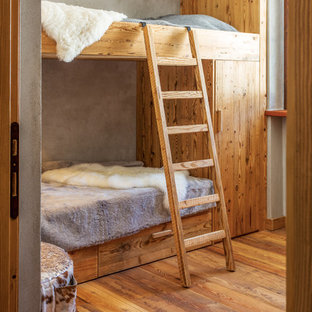Foto di una cameretta per bambini stile rurale con pareti grigie e pavimento in legno massello medio