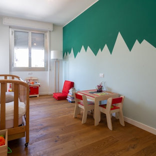 Idee per una cameretta per neonati design con pareti multicolore e pavimento in legno massello medio