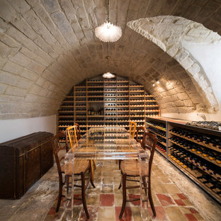 Immagine di una cantina mediterranea con rastrelliere portabottiglie e pavimento multicolore