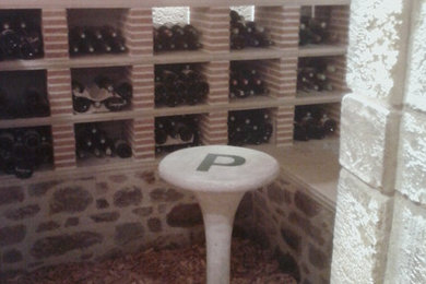 Idée de décoration pour une petite cave à vin tradition avec un sol en brique, des casiers et un sol rouge.