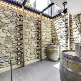 Exemple d'une grand cave à vin méditerranéenne avec béton au sol, un sol gris et un présentoir.