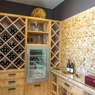 Idée de décoration pour une cave à vin design de taille moyenne avec des casiers losange et un sol en bois clair.