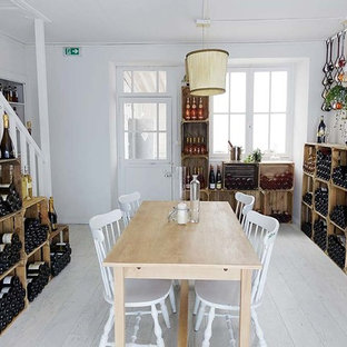 Klassisk inredning av en mellanstor vinkällare, med laminatgolv, vinhyllor och grått golv
