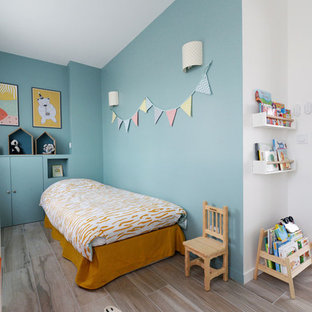 Aménagement d'une chambre d'enfant de 1 à 3 ans scandinave avec un mur bleu et un sol beige.