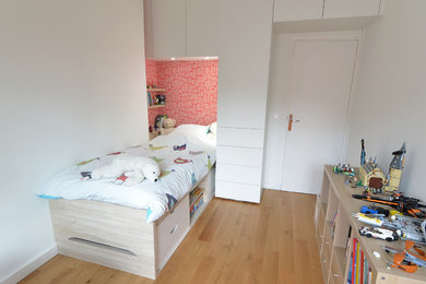 Idée de décoration pour une chambre d'enfant design de taille moyenne avec un mur rouge et parquet clair.