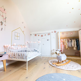 Cette image montre une chambre d'enfant de 1 à 3 ans nordique avec un mur blanc, un sol en bois clair et un sol beige.