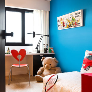 Idée de décoration pour une chambre neutre de 4 à 10 ans design de taille moyenne avec un bureau, un mur bleu et un sol en bois clair.