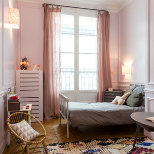 Idées déco pour une grand chambre d'enfant de 4 à 10 ans contemporaine avec un mur rose et un sol en bois brun.