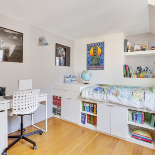 Exemple d'une chambre d'enfant tendance avec un mur blanc, un sol en bois brun et un sol marron.