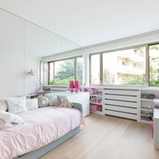 Cette image montre une chambre d'enfant de 4 à 10 ans nordique de taille moyenne avec un mur blanc et un sol en bois clair.