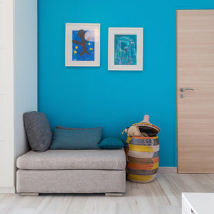 Idée de décoration pour une grand chambre d'enfant de 4 à 10 ans design avec un mur bleu et un sol en bois clair.
