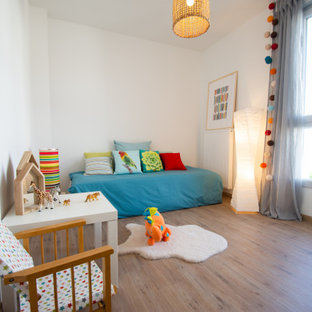 Exemple d'une petit chambre d'enfant de 1 à 3 ans scandinave avec un mur blanc, un sol en bois brun et un sol marron.