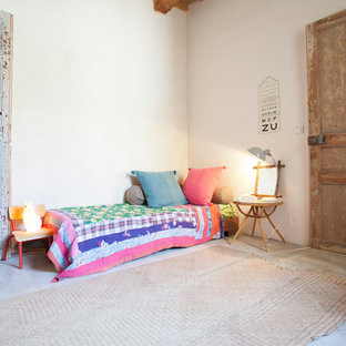 Aménagement d'une grand chambre d'enfant de 4 à 10 ans éclectique avec un mur blanc et béton au sol.