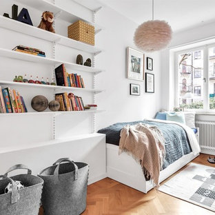Minimalistisk inredning av ett pojkrum kombinerat med sovrum och för 4-10-åringar, med vita väggar, mellanmörkt trägolv och brunt golv