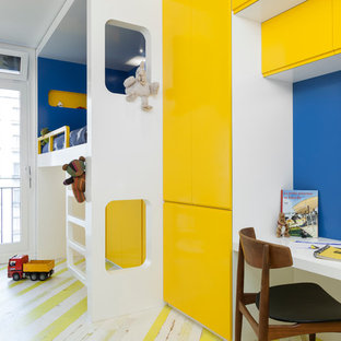 Cette image montre une chambre de garçon de 4 à 10 ans design de taille moyenne avec un bureau, un mur bleu, un sol en bois peint et un sol multicolore.