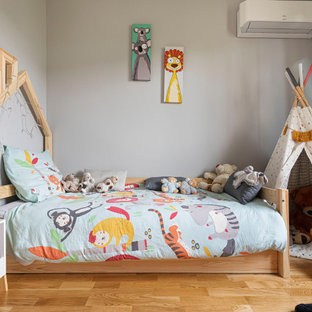 Idées déco pour une petit chambre d'enfant contemporaine avec un mur gris et un sol en bois clair.
