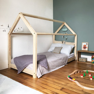 Inspiration pour une chambre neutre nordique avec un mur gris, un sol en bois brun et un sol marron.