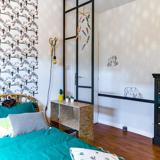 Inspiration pour une chambre neutre de 4 à 10 ans design de taille moyenne avec un mur jaune, un sol en bois foncé et un sol marron.