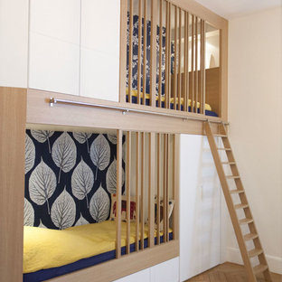 Aménagement d'une chambre d'enfant de 4 à 10 ans contemporaine avec un mur blanc, un sol en bois brun et un sol marron.