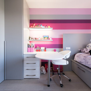 Cette image montre une chambre de fille de 4 à 10 ans design de taille moyenne avec un mur multicolore, un bureau et un sol en bois clair.