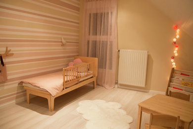 Ispirazione per una cameretta per bambini da 1 a 3 anni tradizionale di medie dimensioni con pareti rosa, parquet chiaro e pavimento beige