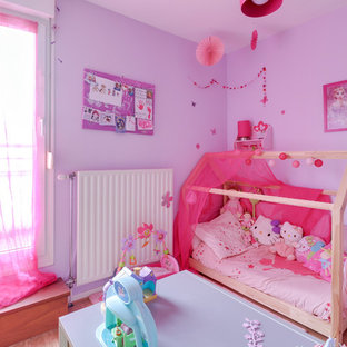 Idées déco pour une chambre d'enfant de 1 à 3 ans classique de taille moyenne avec un mur violet, un sol en bois clair et un sol beige.