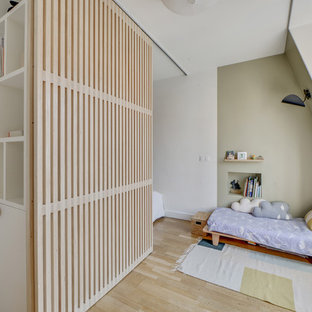 Aménagement d'une chambre d'enfant contemporaine avec un mur vert, un sol en bois clair et un sol beige.