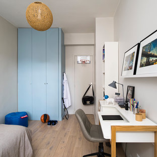 Inspiration pour une chambre d'enfant design avec un mur blanc, un sol en bois clair et un sol beige.