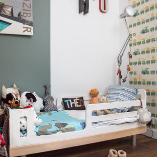 Réalisation d'une chambre d'enfant de 1 à 3 ans bohème de taille moyenne avec un sol en bois foncé et un mur gris.