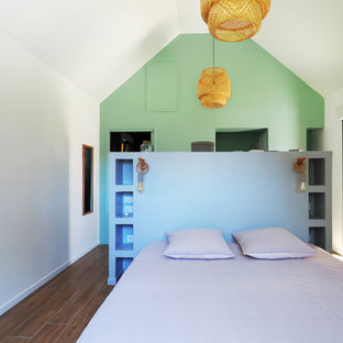 Idée de décoration pour une chambre d'enfant marine avec un mur blanc, un sol en bois brun et un sol marron.