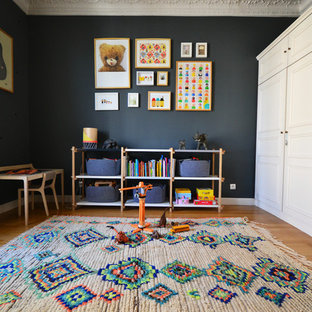 Cette image montre une grand chambre d'enfant de 4 à 10 ans design avec un mur bleu et un sol en bois clair.