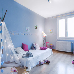Aménagement d'une chambre d'enfant de 4 à 10 ans classique de taille moyenne avec un mur bleu et un sol en bois brun.