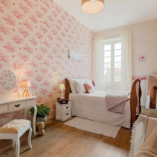 Réalisation d'une chambre d'enfant tradition avec un mur rose, un sol en bois clair et un sol marron.