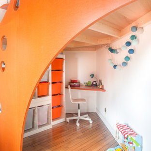 Aménagement d'une chambre neutre de 4 à 10 ans contemporaine de taille moyenne avec un bureau, un mur blanc et un sol marron.