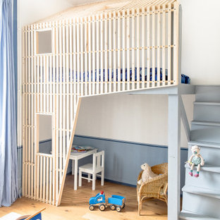 Modelo de dormitorio infantil de 4 a 10 años, contemporáneo, de tamaño medio, con paredes blancas, suelo de madera clara y suelo beige