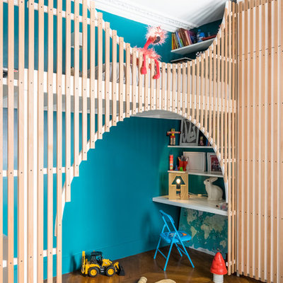 Example of a trendy medium tone wood floor and brown floor kids' room design in Paris with blue walls