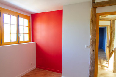 Exemple d'une chambre d'enfant de 4 à 10 ans de taille moyenne avec un mur rouge et un sol en bois brun.