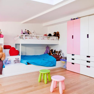 Aménagement d'une grand chambre d'enfant de 4 à 10 ans contemporaine avec un mur blanc et un sol en bois clair.