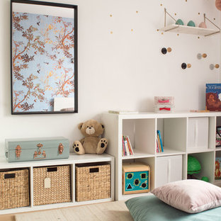 Exemple d'une chambre d'enfant chic avec un mur blanc et un sol en bois clair.