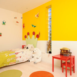 Inspiration pour une chambre d'enfant de 4 à 10 ans design avec un sol en bois clair et un mur multicolore.