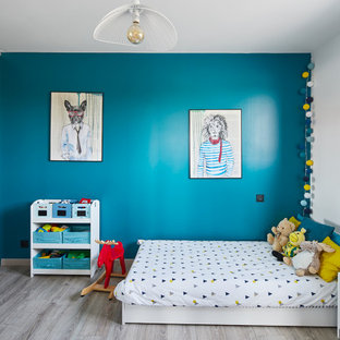 Foto di una cameretta per bambini da 4 a 10 anni scandinava di medie dimensioni con pareti blu, pavimento in laminato e pavimento grigio