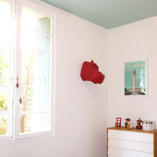 Esempio di una grande cameretta neutra da 4 a 10 anni mediterranea con pareti bianche, pavimento in laminato e pavimento beige