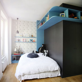Inspiration pour une chambre d'enfant design avec un mur noir, un sol en bois clair et un sol marron.