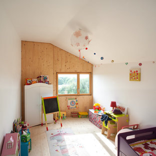 Idées déco pour une chambre d'enfant de 1 à 3 ans contemporaine avec un mur blanc et un sol en bois clair.