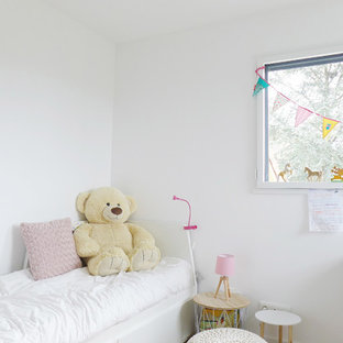 Réalisation d'une chambre d'enfant design de taille moyenne avec un mur blanc, un sol en bois clair et un sol beige.
