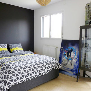 Modern inredning av ett mellanstort barnrum, med svarta väggar, ljust trägolv och beiget golv
