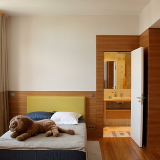 Idée de décoration pour une chambre d'enfant minimaliste de taille moyenne avec un mur blanc et un sol en bois brun.