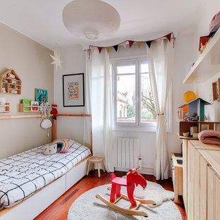 Idée de décoration pour une chambre d'enfant design avec un mur gris, un sol en bois foncé et un sol marron.
